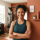 A happy, diverse person smiling in a bright, modern home gym setting.